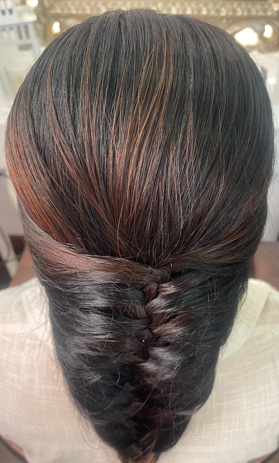 Trança elegante em cabelo escuro com reflexos
